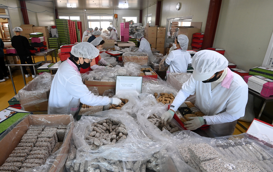 Hangwa, traditional Korean sweets, are packaged at a factory in Gangneung in Gangwon Province on Wednesday. The sweets are often exchanged as gifts for the Lunar New Year, which falls on Feb. 1 this year. [YONHAP] 