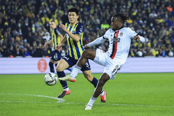 Fenerbahce's Kim Min-jae, left, vies for the ball with Besiktas' Michy Batshuayi during a Turkish Super League match at the Sukru Saracoglu stadium in Istanbul, Turkey on Dec. 19, 2021. [AP/YONHAP]