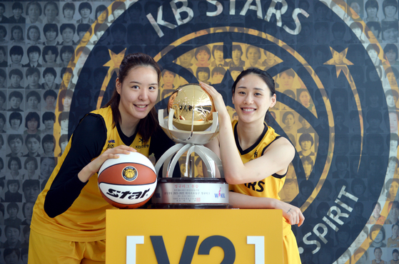 Cheongju KB Stars Park Ji-su, left and Kang Lee-seul celebrate winning the 2021-22 WKBL regular season at the KB Financial Group Training Center in Cheonan, South Chungcheong on Monday. [JOONGANG ILBO]