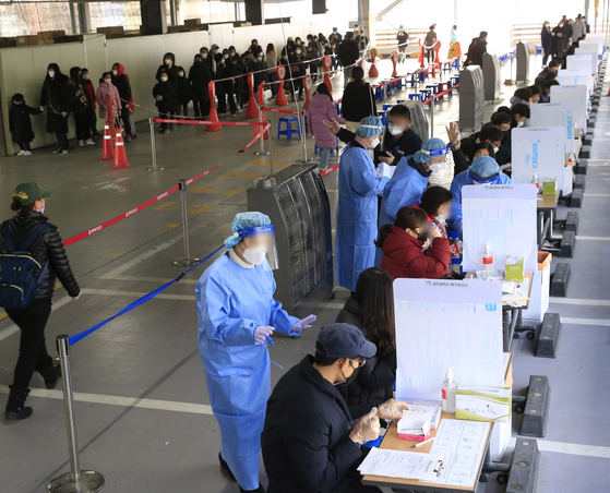 Health workers supervise people taking Covid-19 rapid antigen tests at a public health center in Gwangju Wednesday, the first day a new testing and treatment system tailored to the spread of Omicron was implemented in four areas of the country. Starting Feb. 3, the system will be expanded nationwide, and rapid antigen tests will replace PCR tests, except for people aged over 60 or high-risk groups, while local hospitals and clinics will test and treat patients. [JANG JUNG-PIL]