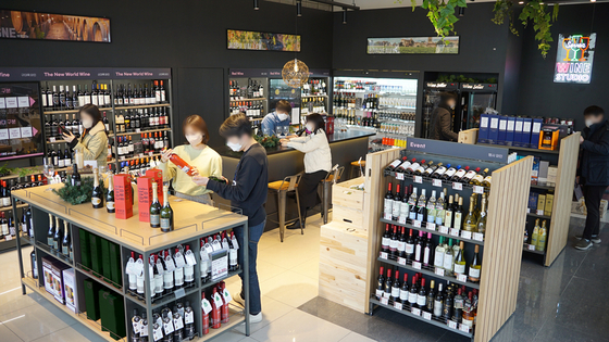 Customers shop at 7-Eleven's remodeled wine store in Yeoksam-dong, southern Seoul, on Dec. 27. 7-Eleven remodeled the second floor of the branch into a store specialized in wine. [7-Eleven]
