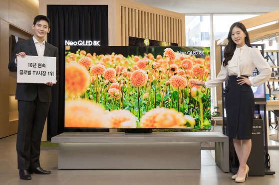 Samsung Electronics ranked No. 1 in the global TV market for the 16th consecutive year, the company said Sunday. According to the electronics maker, the company's TVs took up 29.5 percent of TV sales based on revenue generated from sales and 19.8 percent based on the number of TVs sold. Samsung Electronics models pose beside the company's popular Neo QLED TV model in a showroom in southern Seoul, holding up a sign reading, "16 years global TV market No. 1.″ [SAMSUNG ELECTRONICS]