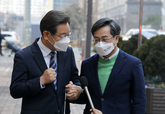 Lee Jae-myung, left, presidential candidate of the Democratic Party, and Kim Dong-yeon, candidate of the New Wave Party, hold hands as they speak to reporters following their meeting at a cafe in Mapo District, western Seoul, on Tuesday. The two issued a joint declaration for political change, having agreed on policy coordination. [NEWS1] 