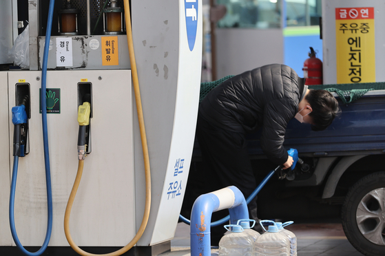 A customer pumps fuel at a gas station on Monday. The rising international oil price is the latest area that is affected by the ongoing conflict between Russia and Ukraine. [YONHAP] 