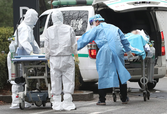 Medical workers in protective gear transfer a Covid-19 patient in an ambulance at Seoul Medical Center in Jungnang District, eastern Seoul, on Sunday. [NEWS1]