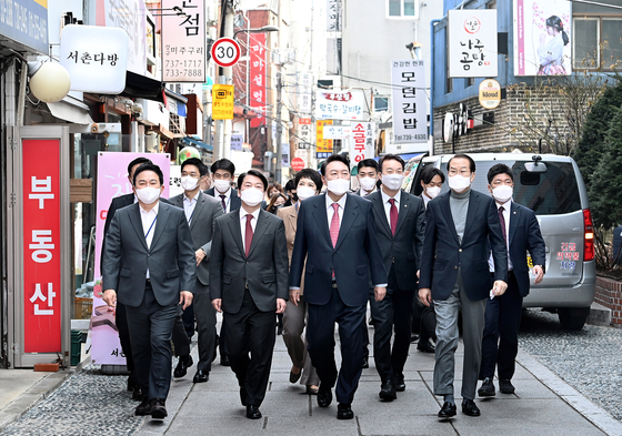 President-elect Yoon Suk-yeol, center, takes a stroll after having lunch with his transition team in Tongui-dong in Jongno District, central Seoul, after the cancelation of a luncheon meeting with President Moon Jae-in on Wednesday. [JOINT PRESS CORPS] 