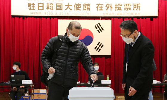 An overseas voter casts his vote in a ballot box at the Korean Embassy in Tokyo Wednesday. Overseas voting for the March 9 presidential election kicked off Wednesday for six days. A total of 226,162 overseas Koreans registered as absentee voters will be eligible to vote at 219 polling stations in 177 missions in 115 countries between 8 a.m. and 5 p.m. daily, according to the National Election Commission. [YONHAP]