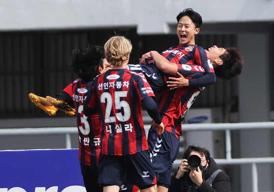 Lee Seung-woo of Suwon FC, center, celebrates with his teammates after scoring against Daegu FC at Suwon Stadium in Suwon, Gyeonggi on Sunday. [YONHAP]