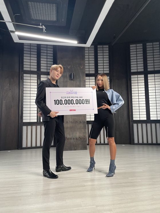 Hyolyn, right, and Junsu with their 100 million won cheque that they received as the final winnners of Watcha-original music competition program, "Double Trouble" on March 18. [ILGAN SPORTS]