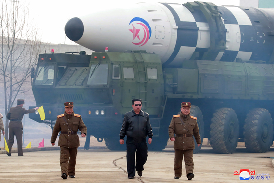North Korean leader Kim Jong-un, center, walks forward in what appears to be a staged photo-op released by the state-run Korean Central News Agency (KCNA) on the occasion of the test launch of an intercontinental ballistic missile on Thursday. Kim is flanked on his right by Jang Chang-ha, chief of the North's National Academy of Defense Science, and Kim Jong-sik, chief of the Workers' Party Military Industry Department on his left. [YONHAP]