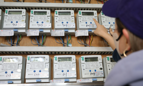 A person checks electricity meters for apartments in Seoul on Tuesday as the state-run Korea Electric Power Corp. (Kepco) announced Tuesday it decided not to increase electricity rates in the second quarter despite high energy prices amid rising inflation. [NEWS1]