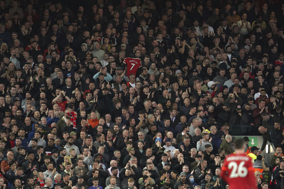 Liverpool fans applaud in support of Manchester United's Cristiano Ronaldo and his family in the seventh minute of a match between Liverpool and Manchester United at Anfield in Liverpool on Tuesday. [AP/YONHAP]