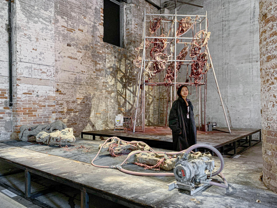 Artist Mire Lee poses in front of “Endless House: Holes and Drips” (2022), now on view at the 59th Venice Biennale's ″The Milk of Dreams.″ [TINA KIM GALLERY]