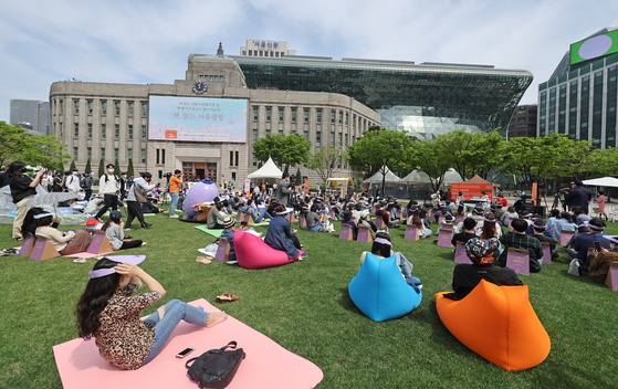 Seoulites enjoy the sunny afternoon Saturday by reading books at the "Read at Seoul Plaza" outdoor library event in front of City Hall in central Seoul on Saturday. [YONHAP]