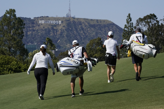Park In-bee, left, Kang Hae-ji and their caddies walk down the ninth fairway during the final round of the DIO Implant LA Open golf tournament at Wilshire Country Club on Sunday in Los Angeles. [AP/YONHAP]