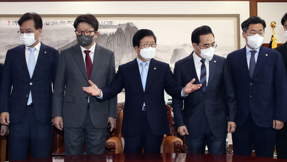National Assembly Speaker Park Byeong-seug, center, poses with the Rep. Park Hong-keun, Democratic Party floor leader, second from right, and Rep. Kweon Seong-dong, People Power Party floor leader, second from left, ahead of a meeting Tuesday morning to discuss renegotiating a compromise on a bill at the National Assembly in Yeouido, western Seoul. [KIM SANG-SEON]