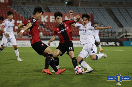 Oh Jae-hyuk of Bucheon FC 1995, center plays the ball against Kim Sang-won of Suwon FC at Bucheon Stadium in Bucheon, Gyeonggi on Wednesday. [KFA]