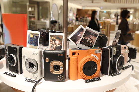 Shoppers browse cameras at a store in Seoul, Monday. Following the lifting of most social distancing measures, many are returning to offices which has led to a rise in demand for business suits. Cameras have also seen an increase in sales as people head outdoors. [YONHAP]