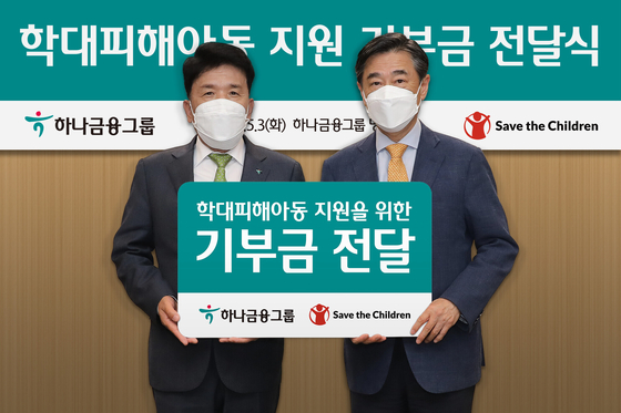 Hana Financial Group Chairman Ham Young-joo, right, poses for a photo with Oh Joon, the chair of the Korean board of Save the Children, during a donation ceremony held at Hana Financial Group's Myeongdong office in central Seoul, Tuesday. [HANA FINANCIAL GROUP]
