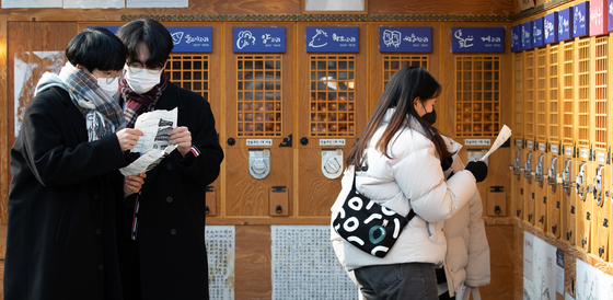 People read the papers telling their fortune for the year, according to their 12 zodiac animals, in central Seoul on Dec. 30. [NEWS1]