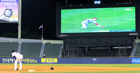 Doosan Bears outfielder Jo Soo-haeng watches as a video replay shows SSG Landers outfielder Oh Tae-gon failing to catch the ball in the 11th inning of a game against the Doosan Bears at Jamsil Baseball Stadium in southern Seoul on Wednesday.