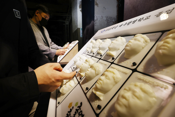 Visitors at "Touch in the Dark" exhibition are welcome to feel the yearbooks, shown here, as well as the crafts on display. [YONHAP]
