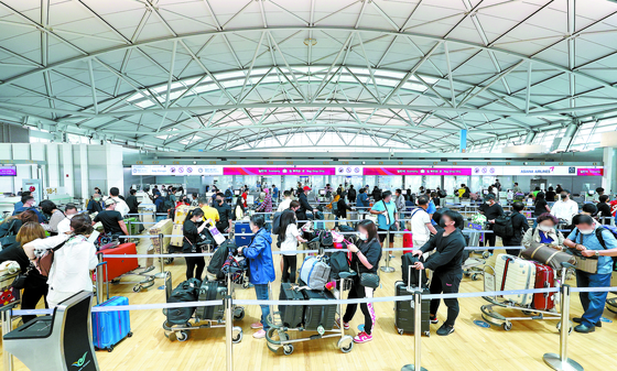 Tourists wait to depart from Terminal 1 of Incheon International Airport on Wednesday afternoon as the number of people going on vacations overseas has increased with the easing of quarantine and testing measures. [YONHAP]