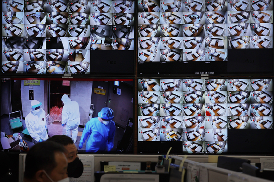 Security camera screens show empty wards and medical staff leaving a Covid-19 residential treatment center in Seoul on Tuesday. With the continuing drop in Covid-19 cases, most community treatment centers and temporary screening clinics will stop operating from Wednesday. [YONHAP]