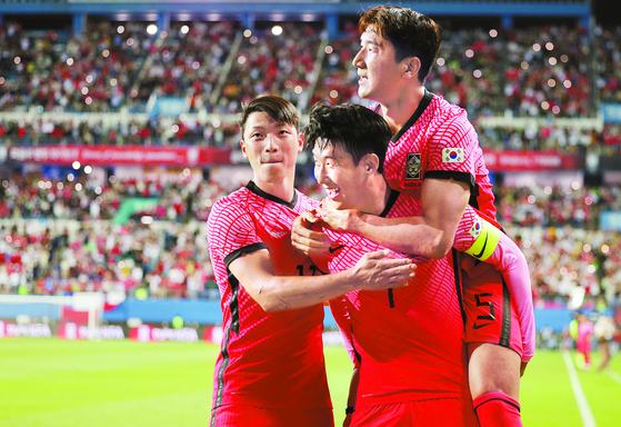 Son Heung-min, center, celebrates with Hwang Hee-chan, left, and Jung Woo-young after scoring Korea’s second goal in a 2-0 win against Chile at Daejeon World Cup Stadium in Daejeon on Monday. The game marked Son’s 100th appearance with the national team. [YONHAP]