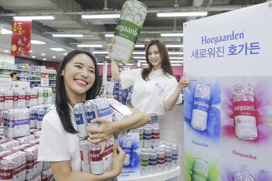 Hoegaarden will host a beer tasting event at over 100 discount marts including Emart and Homeplus from June 10 to 12 to promote its renewed package design catering to younger consumers. Models pose at the Homeplus Jamsil branch in southern Seoul on Wednesday to promote the tasting event. [YONHAP]