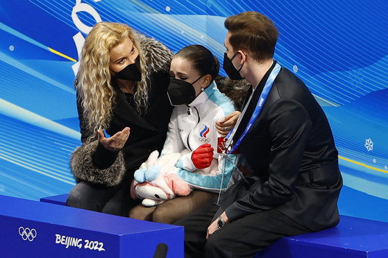Coach Eteri Tutberidze, left, reacts with Kamila Valieva of the Russian Olympic Committee, center, and coach Daniil Gleikhengauz after Valieva's free skate performance at the Capital Indoor Stadium in Beijing on Feb. 17. [REUTERS/YONHAP]