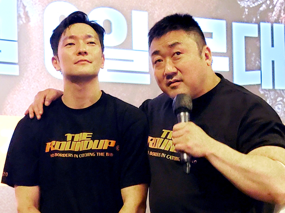 Stars of "The Roundup," actors Son Suk-ku, left, and Ma Dong-seok greet the moviegoers who came to watch their film at CGV Pangyo in Gyeonggi on June 6. [YONHAP]