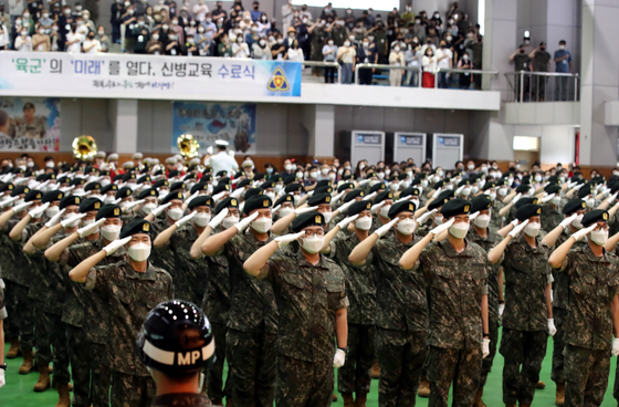 Army recruits salute at a ceremony to mark the completion of boot camp training in Imsil, North Jeolla, on Wednesday. Boot camp completion ceremonies, to which parents and friends are invited, were not held during the Covid-19 pandemic. [YONHAP]