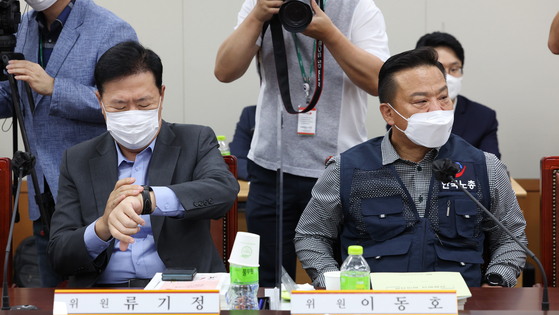 Ryu Ki-jung, left, business representative and director at the Korea Enterprise Federation, and Lee Dong-ho, general secretary of the Federation of Korean Trade Unions, six next to each other at the government complex in Sejong on Thursday. The two sides along with the government have entered the fourth meeting to set next year's minimum wage and discuss the implementation of the wage differential system. The two sides have failed to reach a consensus. [YONHAP]