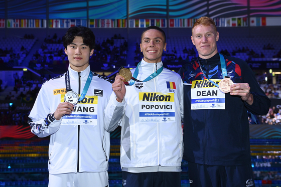 Hwang Sun-woo, left, celebrates with gold medal winner David Popovici of Romania and bronze medal winner Tom Dean of Britainon the podium after winning the men's 200-meter freestyle silver medal at the FINA World Championships in Budapest, Hungary on Monday. [EPA/YONHAP]
