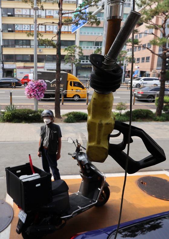 The average gasoline price nationwide reached 2,119.53 won per liter ($6.2 per gallon) on Wednesday, up 3.18 won from the previous day, according to Opinet, the Korea National Oil Corporation's official oil price management system website. The average price of diesel recorded 2,132.23 won per liter, a record-high figure, up 4.69 won from the previous day. A person stands at a gas station in Seoul on Wednesday afternoon. [YONHAP]