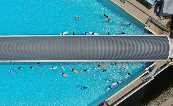 People ride surf boards at an artificial surfing pool in Siheung, Gyeonggi, on Sunday. The average temperature surpassed 30 degrees Celsius (86 degrees Fahrenheit) across the country on the same day. [NEWS1]