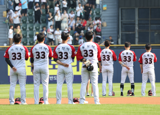 LG Twins players, all in No. 33 jerseys bearing Park Yong-taik's name or one of his nicknames, stand for the national anthem at the start of a game against the Lotte Giants at Jamsil Baseball Stadium in southern Seoul on Sunday. [YONHAP]