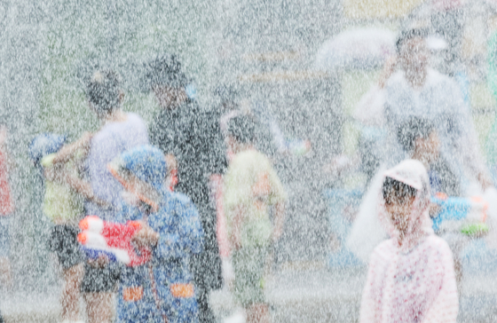 Children get cool at Everland in Yongin, Gyeonggi, on Tuesday amid a continuing heat wave. [YONHAP]