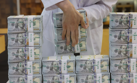 An employee organizes dollars at the Hana Bank Counterfeiting and Forgery Response Center in Jung District, central Seoul, on Tuesday. With the recent stabilization measures of the foreign exchange market following the sharp rise in the won-dollar exchange rate, Korea's foreign currency reserves decreased by $9.4 billion in one month, to $438.2 billion. This is the largest decline since the 2008 global financial crisis. [YONHAP]
