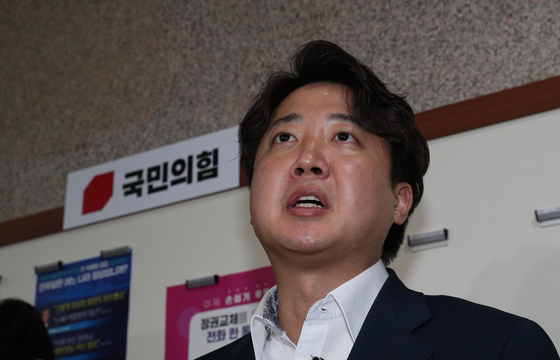 People Power Party Chairman Lee Jun-seok speaks to reporters after he was questioned by the PPP’s ethics committee at the National Assembly in western Seoul early Friday. The committee decided to suspend Lee's party membership for six months. [JOINT PRESS CORPS]