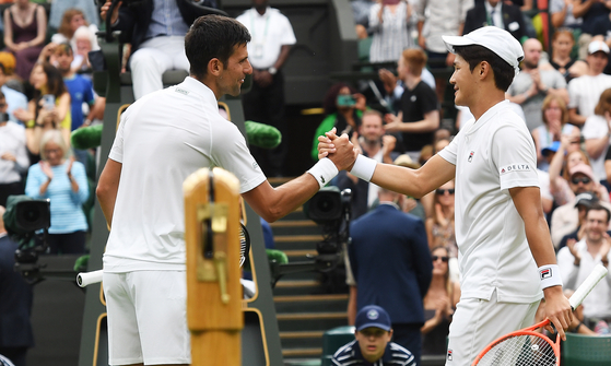 Serbia's Novak Djokovic greets Kwon Soon-woo, right, at the net after winning their men's first round singles match on day one of Wimbledon at the Centre Court of the All England Lawn Tennis and Croquet Club in London on June 27. [EPA/YONHAP]