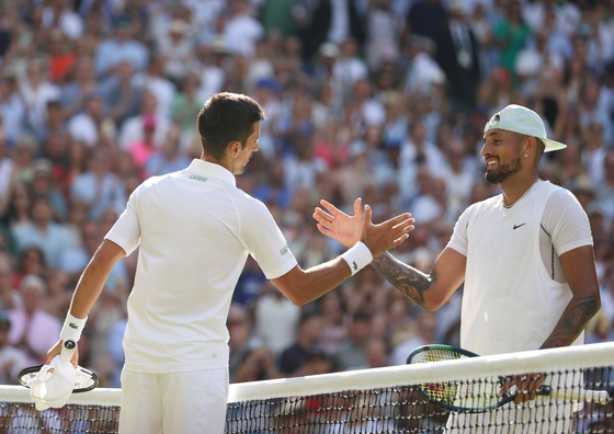 Novak Djokovic, left, greets Nick Kyrgios at the net after winning the men's singles final match between Djokovic and Kyrgios at Centre Court at the All England Lawn Tennis and Croquet Club in London on Sunday. [XINHUA/YONHAP]