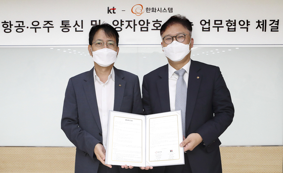 Kim Yi-han, left, head of KT's Institute of Convergence Technology, and Kim Jung-ho, head of Hanwha Systems' control and command system business unit, pose for a photo during a signing ceremony held in Seocho District, southern Seoul. [KT]