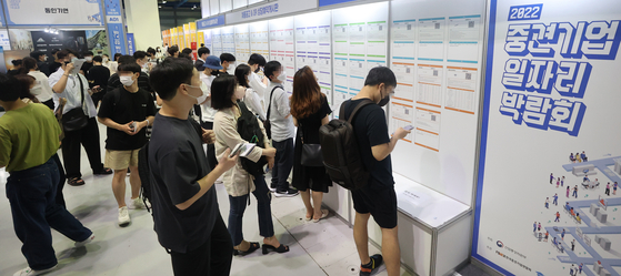 Applicants look at job postings at a job fair held at COEX ,Seoul, earlier this month. [YONHAP] 