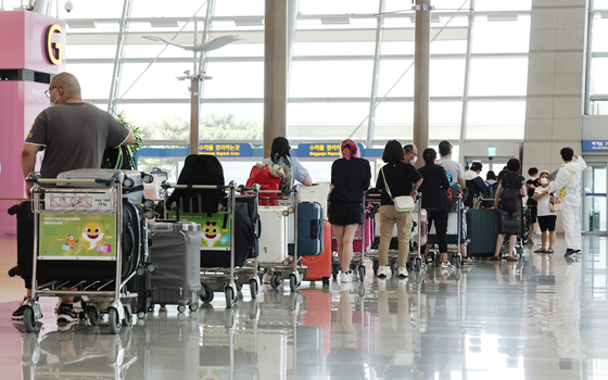 Travelers line up at Incheon International AIrport on Thursday. [YONHAP] 