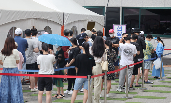 People wait at a Covid-19 testing site in Gangnam District, southern Seoul, on Sunday amid a rising number of infections across the nation. [YONHAP]