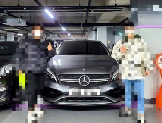A used car dealer and a buyer pose for a photo after a deal is closed. [SCREEN CAPTURE] 