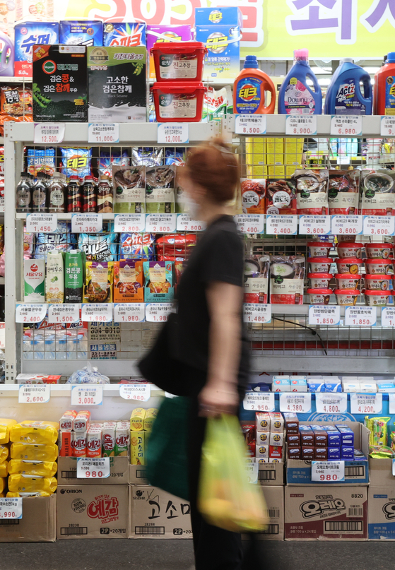 A customer shops at a traditional market in Seoul on Sunday. According to the Bank of Korea, producer prices in June rose for the sixth straight month, adding pressure on consumer prices. Consumer prices in June rose 6 percent but July’s consumer prices could subside thanks to falling international oil prices. [YONHAP] 