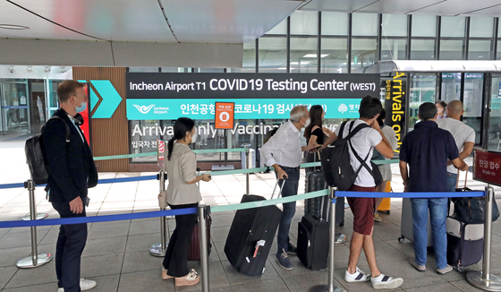 People who entered Korea from abroad line up to get tested for Covid-19 at Incheon Internation Airport on Sunday. [NEWS1]